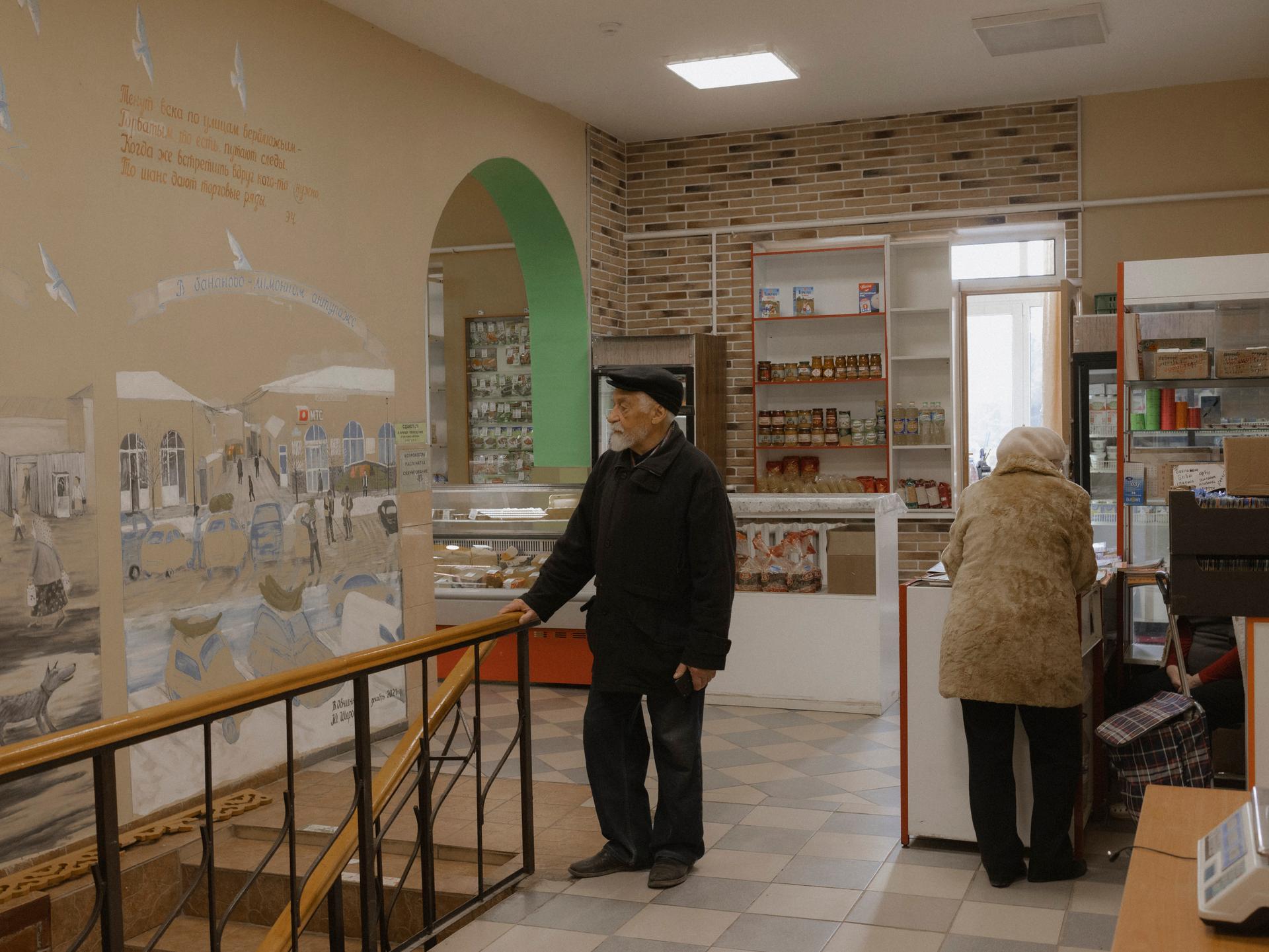 Vladimir Ovtchinnikov devant une de ses fresques représentant trois époques de la ville, à Borovsk (Russie), le 19 avril 2022.