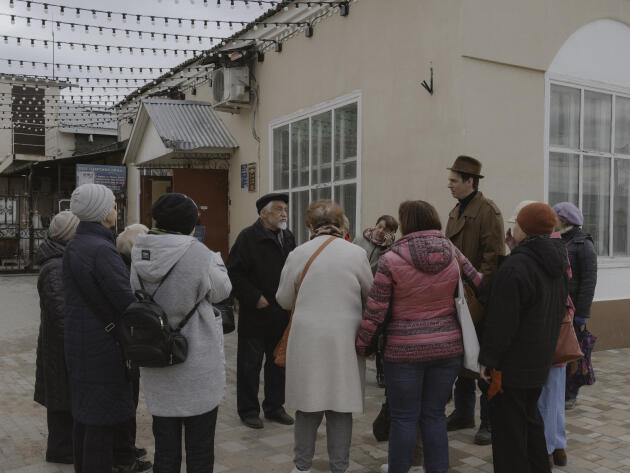 Le peintre Vladimir Ovtchinnikov discute avec un groupe de touristes visitant Borovsk (Russie), notamment pour voir ses œuvres, le 19 avril 2022.
