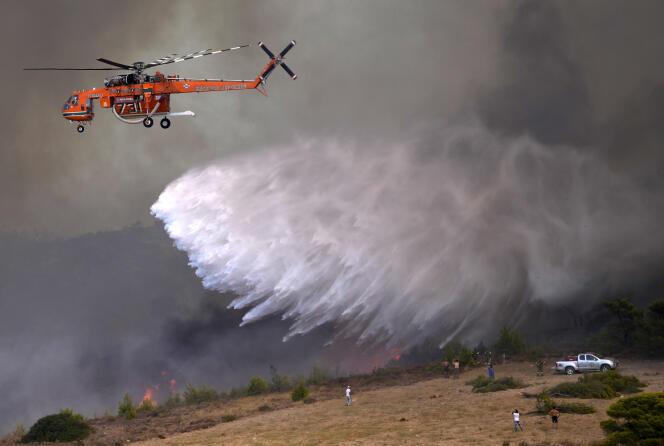 Un helicóptero rocía agua sobre un incendio en el pueblo de Siderina, a unos 55 kilómetros al sur de Atenas, Grecia, el lunes 16 de agosto de 2021.