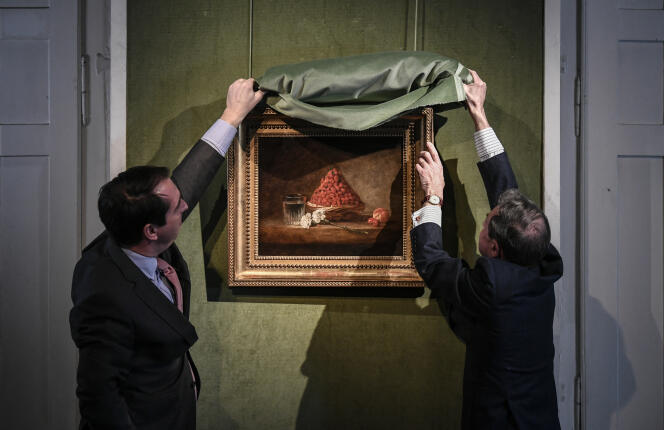 Matthieu Fournier (on the left), auctioneer of the Artcurial auction house, and Eric Turquin (on the right, from behind), director of the Turquin auction house, present, on January 20, 2022, a painting entitled 