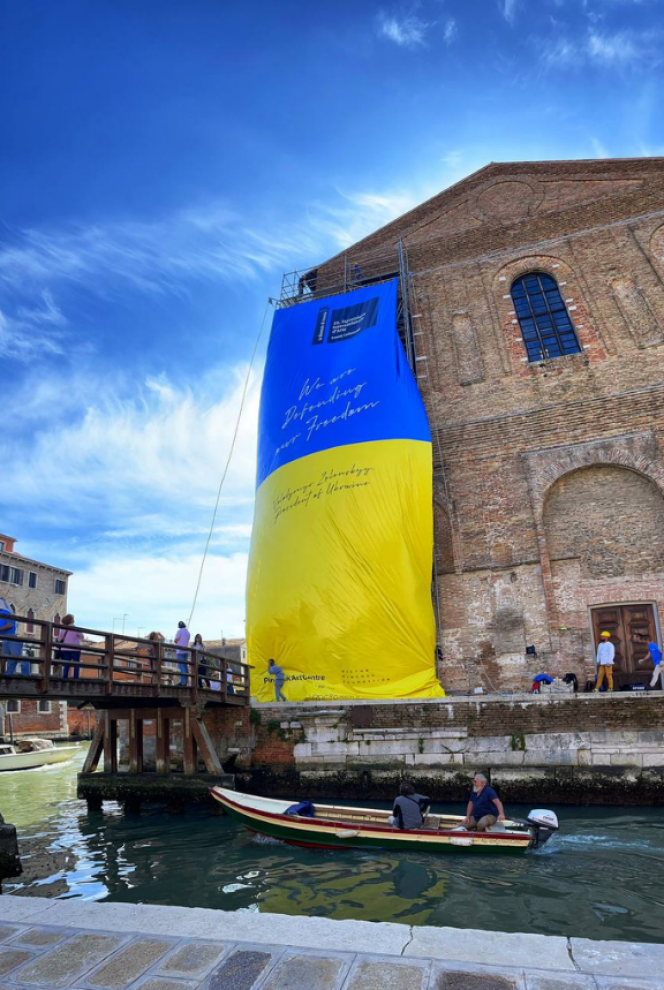 La fachada de la Scuola Grande della Misericordia de Venecia, con la enorme bandera ucraniana, firmada por Zelenski.