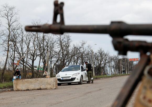 Un membre des troupes prorusses discute avec le conducteur d’un véhicule à un poste de contrôle dans la ville de Marioupol, en Ukraine, le 22 avril 2022.