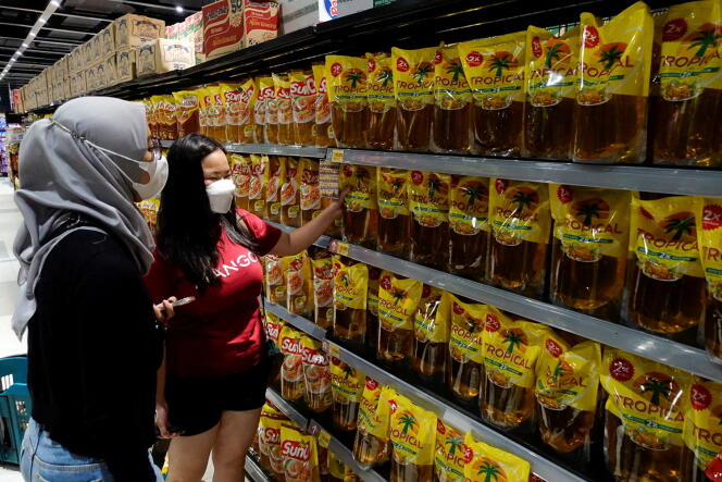 Consumers buy cooking oil made from palm oil at a supermarket in Jakarta, the Indonesian capital, on March 27, 2022.