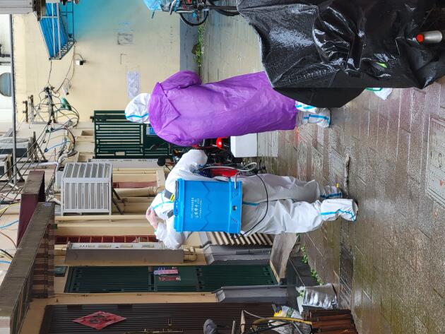Une équipe de désinfection s'apprête à intervenir dans une maison du district de Xuhui, à Shanghaï, en Chine, le 23 avril 2022. La résidente de cette maison a été envoyée dans un centre après avoir été testée positive.