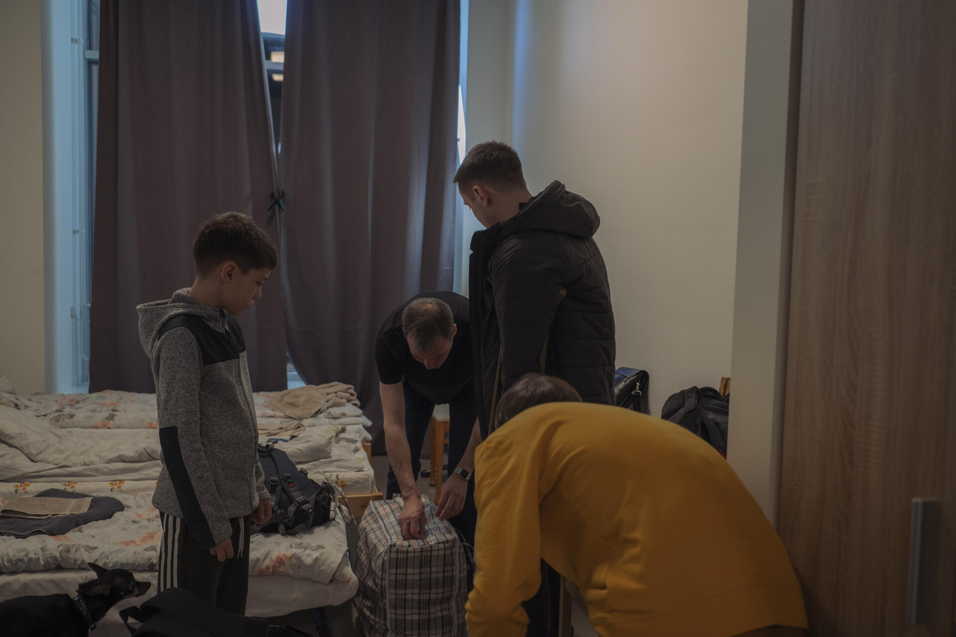 Igor, Edouard, Vlad et Mark préparent leur dernières affaires avant d’aller prendre un train vers Tallinn, le 22 avril 2022, à Narva, en Estonie.
