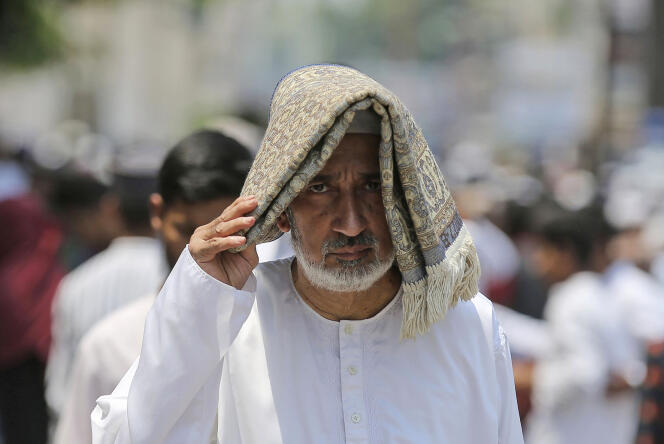 A man protects himself from the sun and sweltering heat after the last Friday prayers of Ramadan, on April 29, 2022, in Hyderabad.