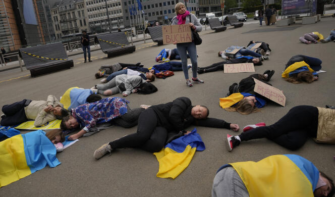 A Bruxelles, le 29 avril 2022, des manifestants s’enroulent dans des drapeaux ukrainiens et demandent aux dirigeants européens d’arrêter d’acheter du gaz et du pétrole russe.