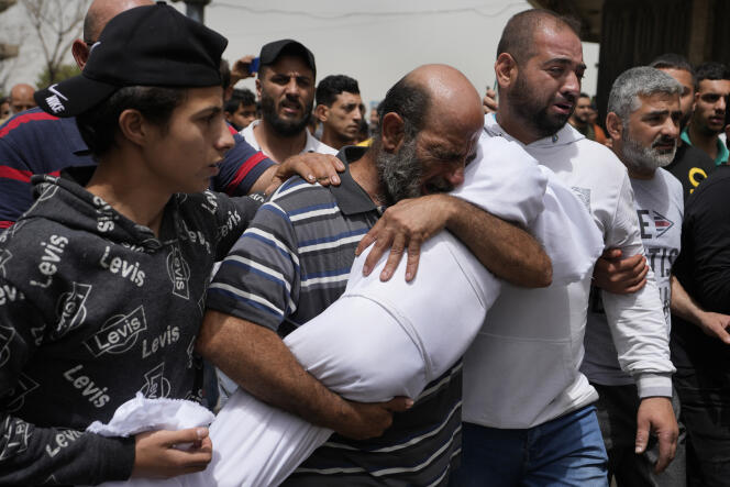 Un homme porte la dépouille d’une petite fille noyée lors du naufrage, le 23 avril 2022, d’un bateau rempli de dizaines de migrants, repoussé par la marine libanaise vers les côtes. Sept corps ont été retrouvés et au moins 23 perosnnes sont portées disparues. A Tripoli, au nord du Liban, le 25 avril 2022.