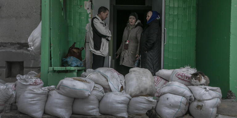 Viktor Rozhkov, Lioudmila et Anna Starostina à l ’entrée de leur immeuble des quartiers de l’Est de Kharkiv, plus proches de la ligne de front, très touché par les obus et les roquettes depuis le début de l’offensive russe. Kharkiv, Ukraine, le 23 avril 2022.