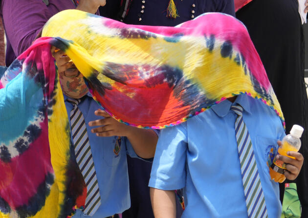 Schoolchildren cover themselves with a scarf against the sun in Prayagraj, northern Uttar Pradesh state, Thursday, April 21, 2022. 