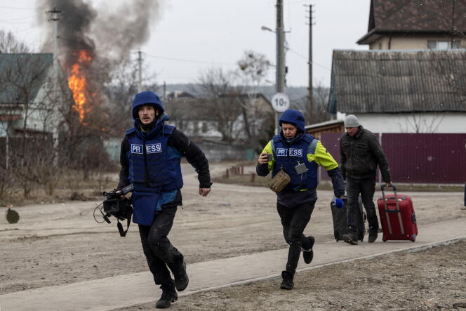 Journalists rush to hide after a bombing, in Irbin (Ukraine), near Kyiv, on March 6, 2022. 