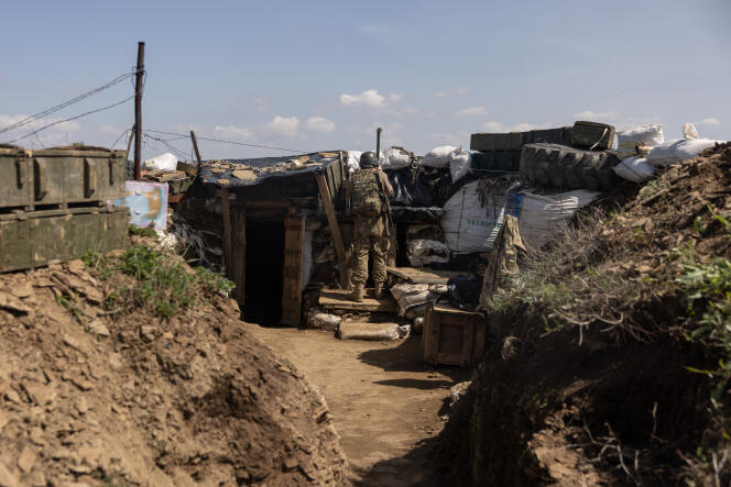 A soldier observes enemy positions on the front line in the trenches east of Bakhmut, Ukraine, in the Donbas.