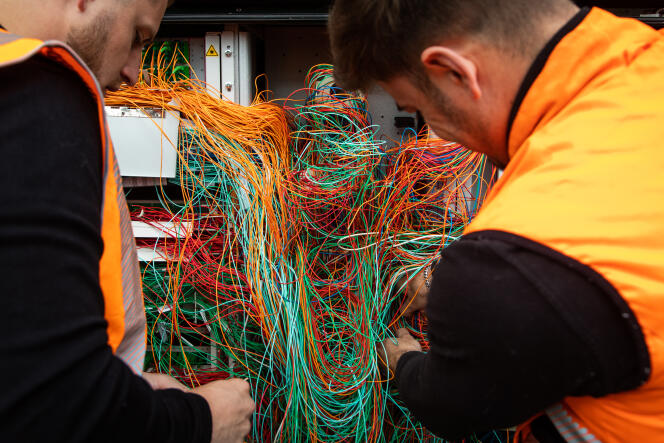 Maintenance d’un point de mutualisation de la fibre optique, à Osny (Val d’Oise), par deux techniciens « Grand Public » de chez Orange, le 25 avril 2022. 