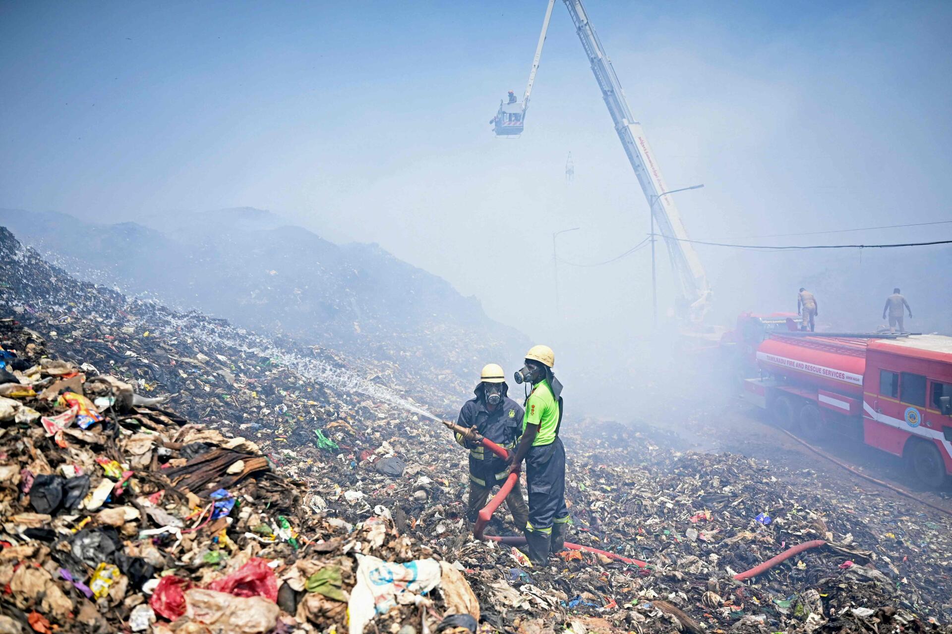 Firefighters try to extinguish burning waste after a fire broke out at the Perungudi landfill site in Chennai, Tamil Nadu, on April 29, 2022.