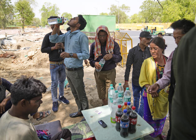 El lunes 11 de abril de 2022, los transeúntes compran agua potable y bebidas en Nueva Delhi. 