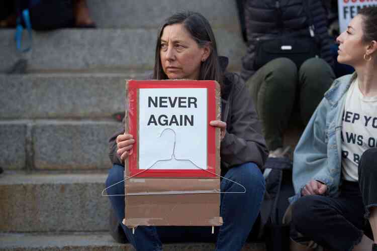 A Boston, une manifestante tient une pancarte « plus jamais », accompagnée d’un cintre en métal, instrument des avortements clandestins qui ont causé la mort de nombreuses femmes avant la dépénalisation de l’avortement.