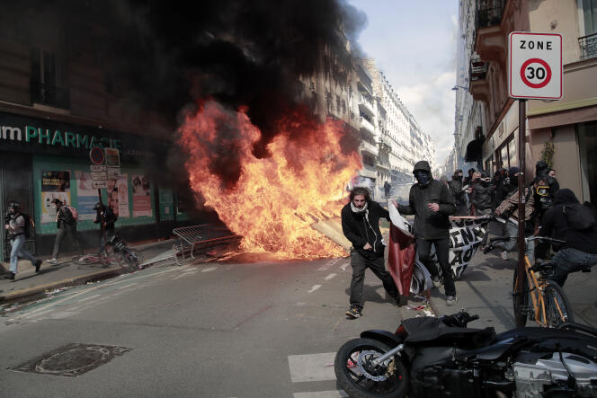 Des manifestants passent à côté d’un feu allumé par d’autres, lors du traditionnel défilé du 1er-Mai, à Paris.