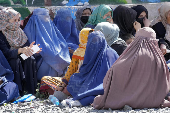 Mujeres afganas, cubiertas con un velo completo, esperan recibir sus raciones de alimentos en Kabul, Afganistán, el 25 de abril de 2022.