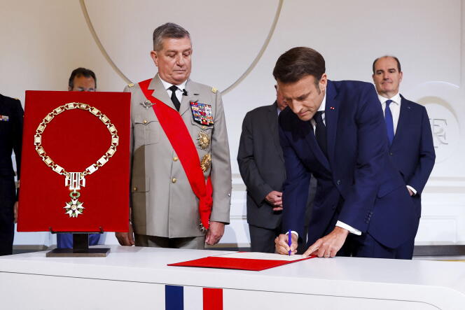 France's Military Chief of Staff to the presidency Benoit Puga, center, left, stands next to French President Emmanuel Macron signing a document during the ceremony of his inauguration for a second term at the Elysee palace, in Paris, France, Saturday, May 7, 2022. 