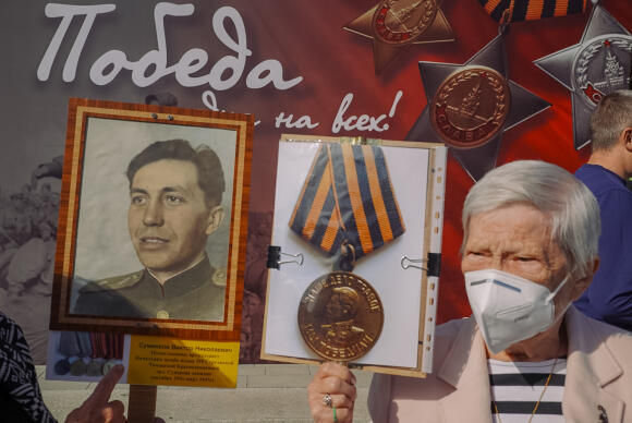 At a rally in Chisinau, Moldova on May 9, 2022.  The protester carries a sign with the ribbon of Saint-Georges.