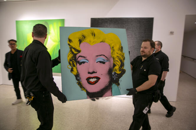 Le portrait « Shot Sage Blue Marilyn », d'Andy Warhol, est transporté dans la salle des ventes de Christie's, à New York, le 8 mai 2022. 