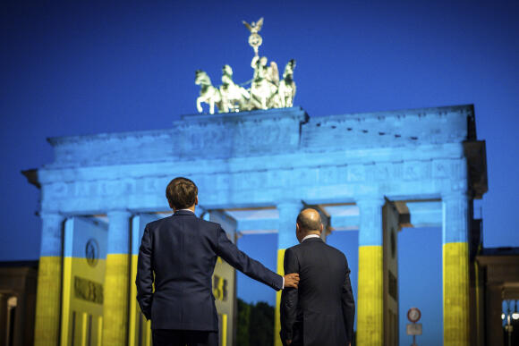 Le président de la République Emmanuel Macron (à gauche) et le chancelier allemand Olaf Scholz (à droite), devant la porte de Brandebourg à Berlin, lundi 9 mai 2022.