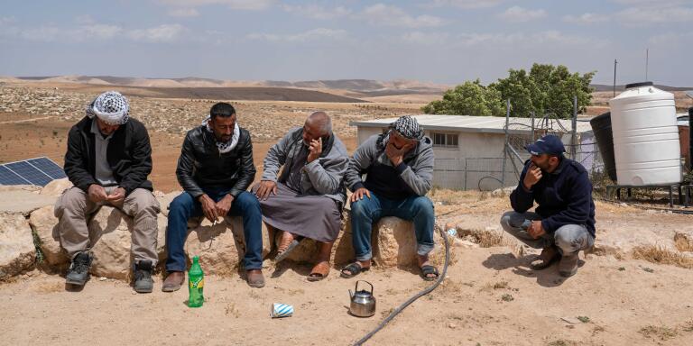 Palestinian activist Fuad el-Imor (2-L) chats to the men in the village of Jinba, in Massafer Yatta on May 6, 2022.