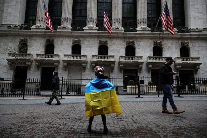 Artist Kristen Visbal's Fearless Girl statue stands draped in the flag of Ukraine after a protest outside the New York Stock Exchange on May 4, 2022.