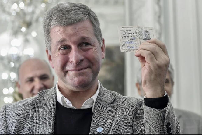 An emotional Edgardo Esteban holds up his military card at the end of an official handover ceremony held at the Ministry of Foreign Affairs in Buenos Aires on April 21, 2022.