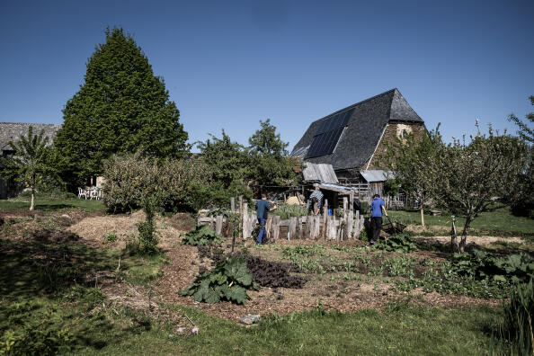 Rémi Richart ancien informaticien, aujourd'hui lance dans l'installation d'énergies renouvelables jardine avec ces fils pres de sa fermette rénovée et transforme en îlot résilient a Prunet dans le Cantal, France, 2022.