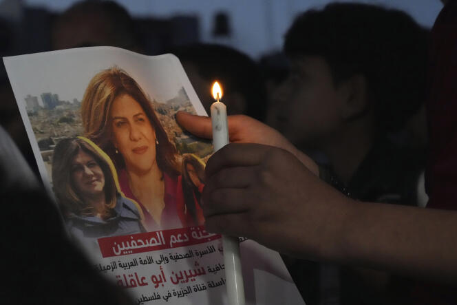Un Palestinien tient un cierge et une photo de la journaliste d’Al-Jazira, Shireen Abu Akleh, tuée lors d’un raid israélien en Cisjordanie, le 11 mai, à Gaza.