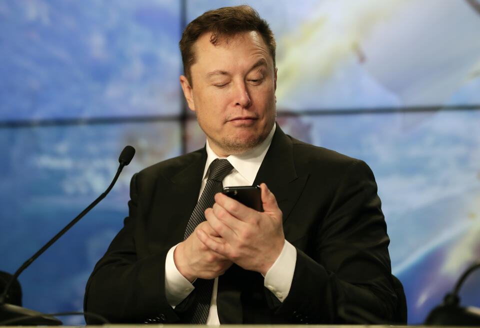 FILE - Elon Musk founder, CEO, and chief engineer/designer of SpaceX jokes with reporters as he pretends to search for an answer to a question on a cell phone during a news conference after a Falcon 9 SpaceX rocket test flight to demonstrate the capsule's emergency escape system at the Kennedy Space Center in Cape Canaveral, Fla., Sunday, Jan. 19, 2020. Many people are puzzled on what a Elon Musk takeover of Twitter would mean for the company and even whether he’ll go through with the deal. If the 50-year-old Musk’s gambit has made anything clear it’s that he thrives on contradiction. (AP Photo/John Raoux, File)