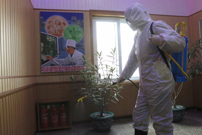 Un responsable du Centre hygiénique et anti-épidémique du district de Phyongchon désinfecte le couloir d’un immeuble, à Pyongyang, le 5 février 2021.