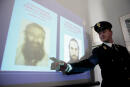 An Italian police officer shows on May 12, 2009 in the |Italian southern city of Bari the pictures of suspected Al-Qaeda members, Bassam Ayachi (L), 63, a Syrian imam who had obtained French nationality and 34-year-old French Raphael Gendron, who were arrested earlier in the day. The two French nationals are thought to have been preparing attacks in France and Britain. AFP PHOTO/GIOVANNI MARINO (Photo by GIOVANNI MARINO / AFP)