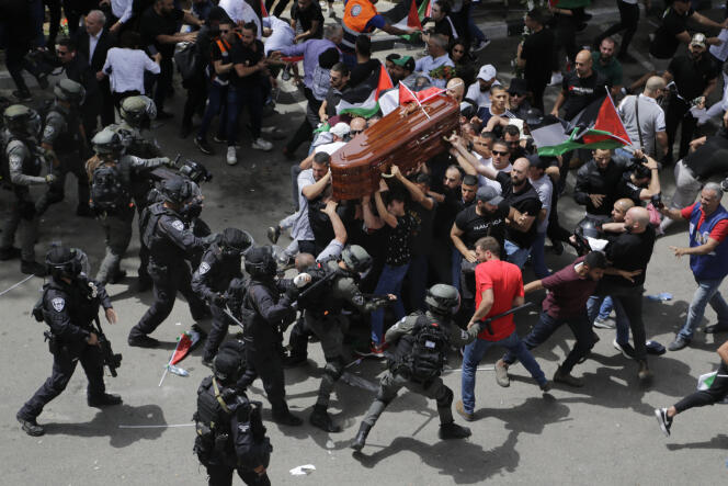 Israeli police charge at mourners as they carry the casket of slain Al Jazeera veteran journalist Shireen Abu Akleh during her funeral in east Jerusalem, Friday, May 13, 2022. 