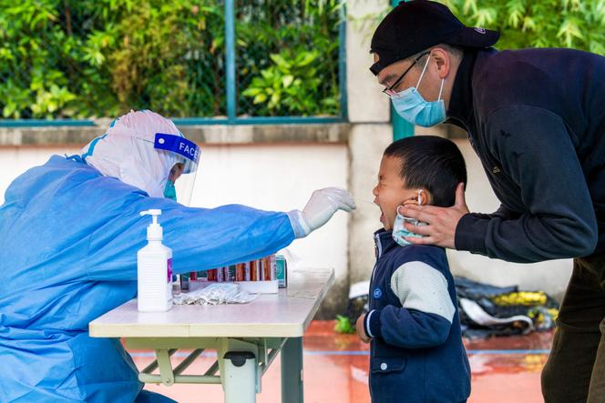 Un enfant subit un test de détéction du SARS-CoV-2 dans le district de Pudong à Shanghaï, le 13 mai 2022.