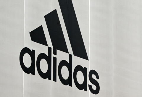 The corporate logo of German sports equipment maker Adidas is seen on a outlet store near the company headquarters in Herzogenaurach, southern Germany, on April 21, 2022. (Photo by Christof STACHE / AFP)