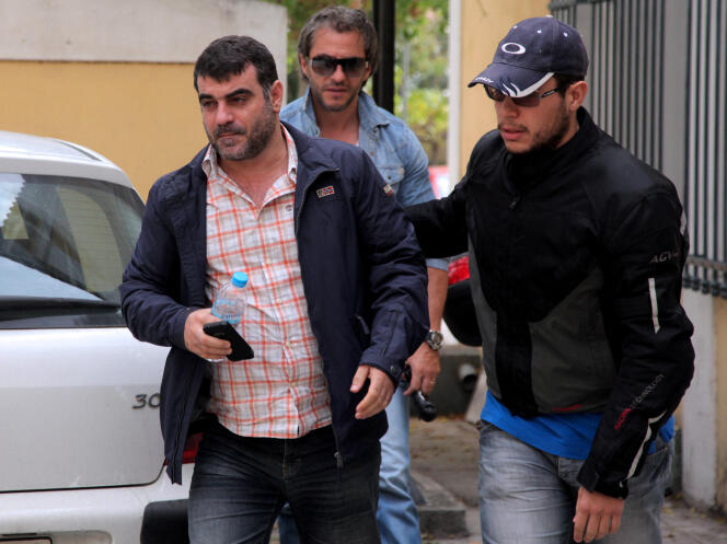 Le journaliste grec Kostas Vaxevanis (à gauche) est escorté par des policiers en civil après son arrestation pour avoir publié dans son magazine les noms d’une liste de Grecs possédant des comptes bancaires suisses, le 18 octobre 2012.