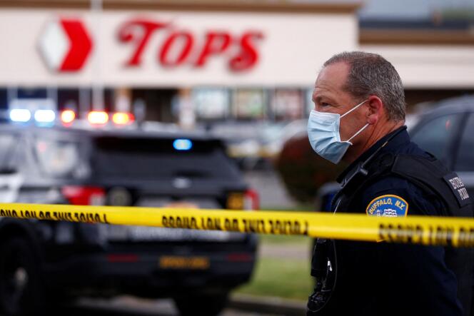 Un policier devant le supermarché où une fusillade a été perpétrée le 14 mai 2022 à Buffalo dans l’Etat de New York. 