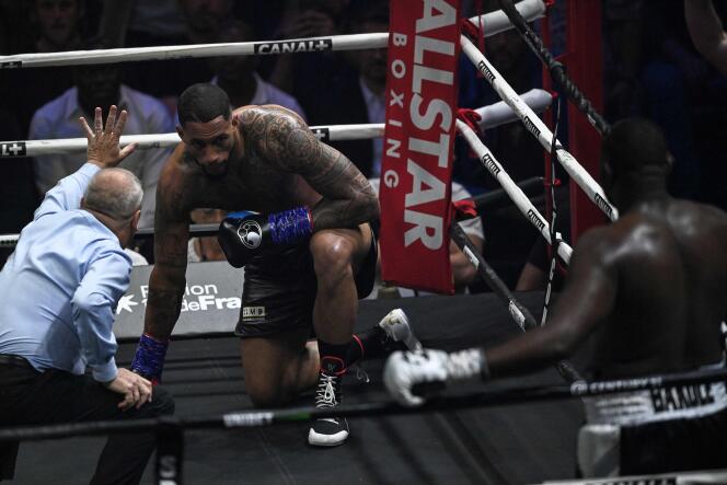 French boxer Tony Yoka (center) knelt at the end of the first round of his fight against Congolese Martin Bakole at the AccorHotels Arena in Paris on 14 May. 