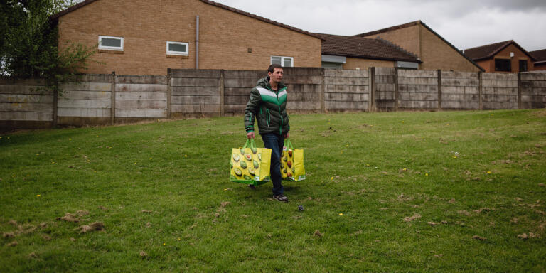 David Ferguson, 41, carries home bags of groceries for him and his mother, from the food bank held at the Trinity Baptist church in Radcliffe, England, on May 6, 2022. David has been unemployed since February, and says that his gas and electricity bills have doubled in price. He and his mother both use the food bank to make ends meet.

Philip Hatcher-Moore for Le Monde