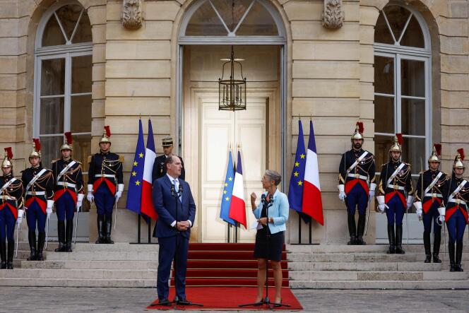 France's outgoing prime minister Jean Castex (L) listens to the speech of his successor, former minister of labor Elisabeth Borne (R), during a handover ceremony in the courtyard of the Hotel Matignon, the French prime minister's official residence, in Paris on May 16, 2022.