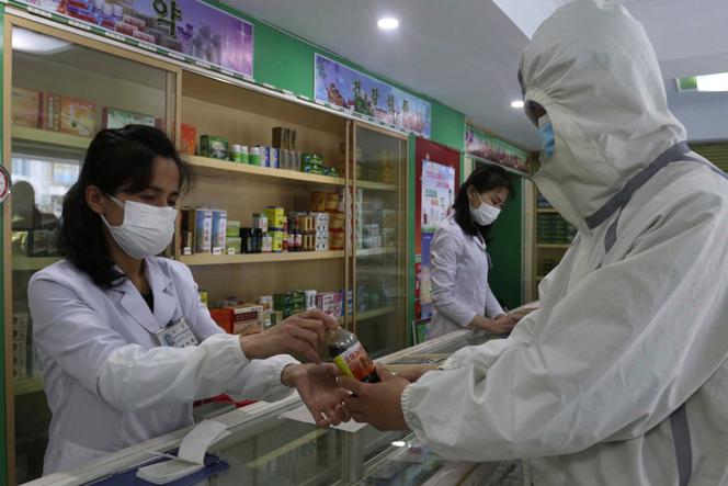 An employee of the Medicament Management Office of the Daesong District in Pyongyang provides medicine to a resident in Pyongyang, North Korea, Monday, May 16, 2022. 