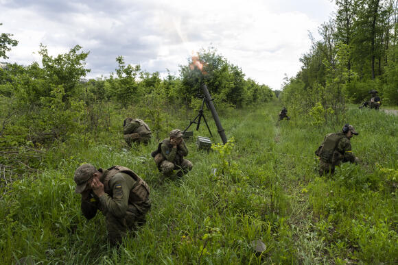 Des militaires ukrainiens accompagnés de membres de la légion étrangère tirent au mortier sur des positions russes dans la région orientale de Kharkiv, en Ukraine, mardi 17 mai 2022.