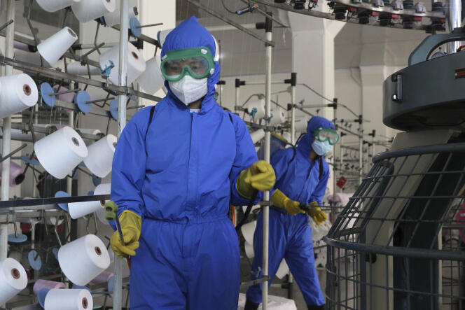 Employees disinfect the Songyo knitting factory in Pyongyang, North Korea, May 18, 2022.