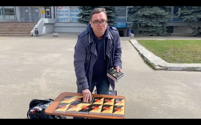 Dmitri Siline installe le présentoir sur lequel il propose le livre de George Orwell « 1984 », dans le centre-ville d’Ivanovo, en Russie, le 1er mai 2022.
