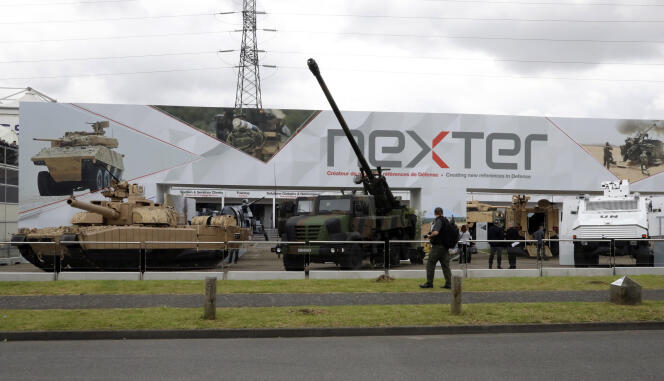 Un visiteur passe devant un char Leclerc (à gauche), un canon Caesar (au centre) et un autre véhicule militaire présentés par Nexter lors d’une exposition à Villepinte (Seine-Saint-Denis), en banlieue parisienne, le 13 juin 2016.