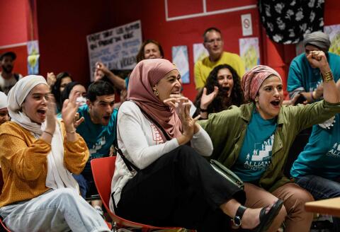 Members of the pro-burkini association « Alliance Citoyenne » watch the Municipal Council on a TV screen and celebrate as members of the municipal council vote to allow the wearing of the burkini in the city’s swimming pools, in Grenoble on May 16, 2022. (Photo by JEFF PACHOUD / AFP)