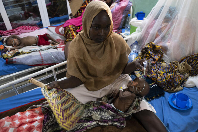 Mariam évente son fils Ali dans le service de soins intensifs de l’hôpital Tchad-Chine, à N’Djamena, le 13 mai 2022. Ali souffre de lésions cutanées en raison de la dégradation de ses cellules due à la malnutrition.