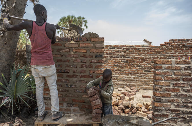 Les fils de Salomon, le porte-parole du camp de Kalambari, construisent un abri avec des briques fournies par le Haut Commissariat des Nations unies pour les réfugiés (HRC).